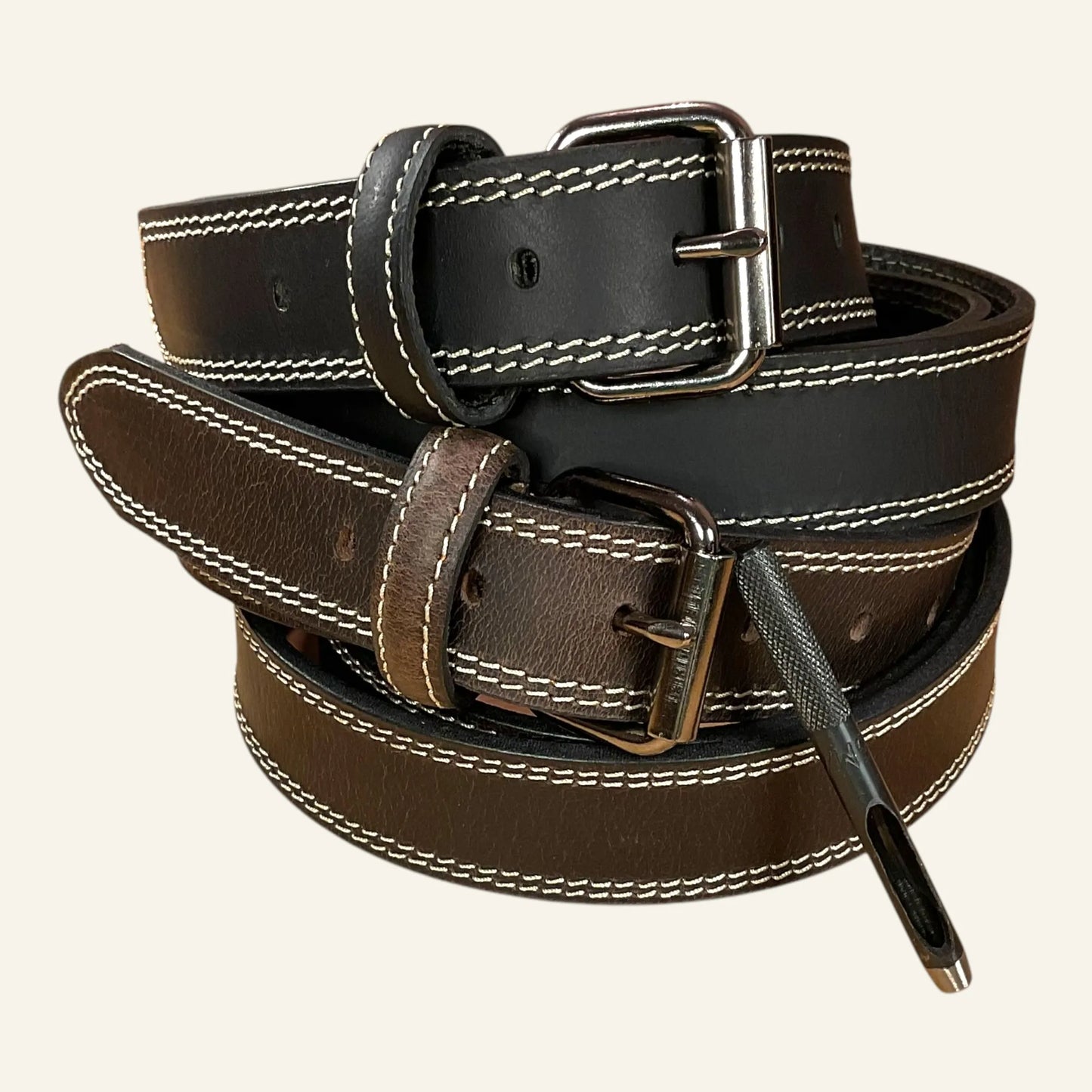 Ceintures en cuir marron et noir avec une double piqure et boucle rouleau. Avec en cadeau un poinceau de mise à la taille